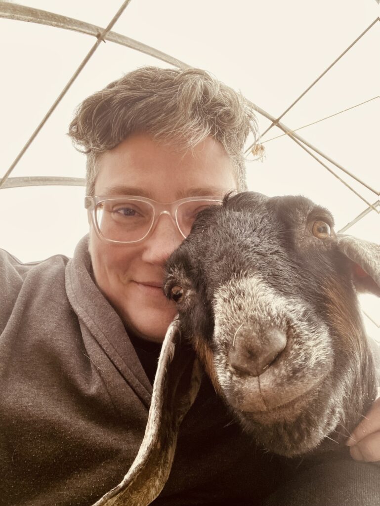 Can you join a coaching session from a goat barn? Absolutely. I'm Lee, a neurodivergent coach, and I took this selfie is a moment of pure autistic joy.